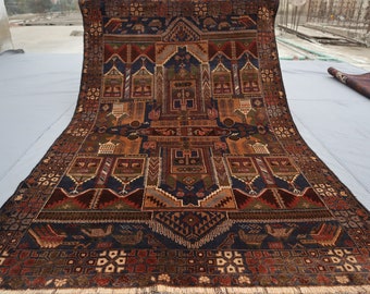 May include: A traditional Persian rug with intricate geometric patterns in shades of red, blue, green, and brown. The rug has a fringed edge and is folded in half.