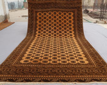 Könnte beinhalten: Ein großer, kunstvoll gemusterter Teppich in Braun- und Orangetönen. Der Teppich hat ein geometrisches Muster mit sich wiederholenden Motiven.