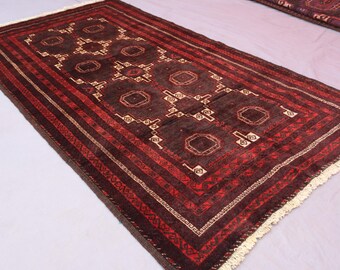 Puede incluir: Alfombra rectangular tejida a mano con un patrón central de formas geométricas en marrón y beige. La alfombra presenta un borde rojo con rayas y un borde con flecos. La alfombra mide aproximadamente 152 cm de largo y 91 cm de ancho.