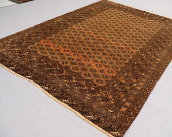 May include: A brown and orange patterned rug with a geometric design. The rug has a fringe border.