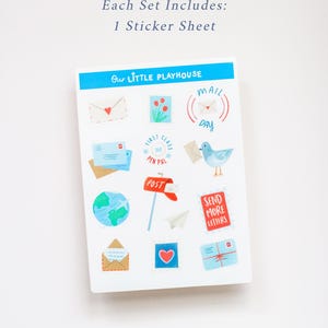 May include: A sticker sheet with various postal-themed illustrations, including envelopes, a globe, a mailbox, and a bird carrying a letter. The text "Our Little Playhouse" and "Mail Day" are visible. The set includes one sticker sheet.