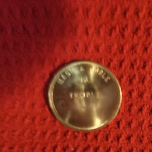 May include: A gold-colored token with the words "Read a Bible in Temple" inscribed on it.