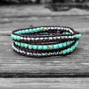 May include: A turquoise and silver wrap bracelet with brown leather cord. The bracelet is made with small round turquoise beads and silver beads.