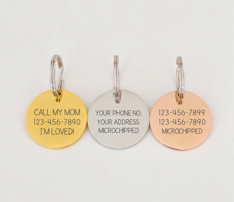 Puede incluir: Tres chapas redondas de metal para perros con llaveros. La chapa dorada dice "CALL MY MOM 123-456-7890 I'M LOVED!" La chapa plateada dice "YOUR PHONE NO. YOUR ADDRESS MICROCHIPPED". La chapa de oro rosa dice "123-456-7899 123-456-7890 MICROCHIPPED".