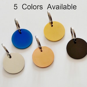 May include: Five round metal tags in various colors: blue, gold, black, beige, and copper. Each tag has a silver-colored ring attached at the top. The text "5 Colors Available" is displayed above the tags.