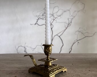 French antique bronze candlestick holder with ornate design trim and fleurs de lys emblems.