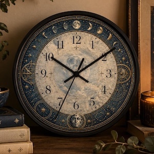 May include: A round wall clock with a black frame featuring a central cream-colored dial with black numerals. The outer border displays a blue celestial map with gold stars, moon phases, and a small moon face at the bottom position.