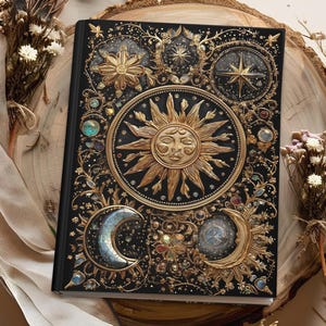 May include: Black journal with a celestial design. The cover features a gold sun, crescent moons, stars, and floral accents. The journal is embellished with colourful gemstones and intricate details, creating a mystical aesthetic.