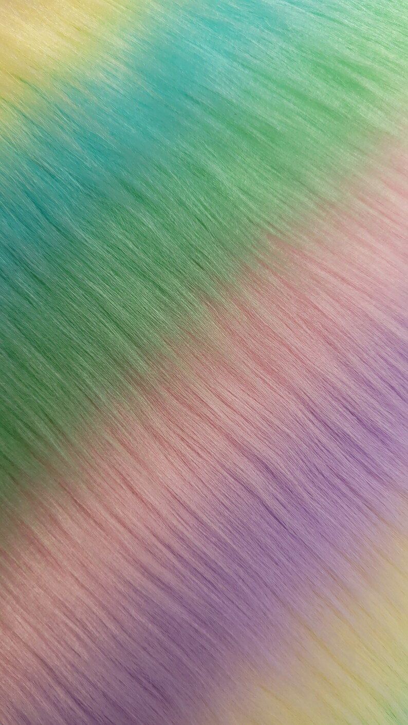 May include: A close-up of a rainbow ombre hair extension. The hair is straight and the colours transition from yellow to green to purple.