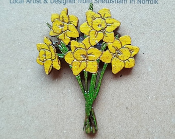 Puede incluir: Un ramo de madera de narcisos amarillos con tallos verdes. Las flores están pintadas con un acabado brillante. El texto "Tide to Nature" está en la parte superior de la imagen. El texto "Lindsey Skipper" está debajo de la primera línea de texto. El texto "Local Artist & Designer from Snettisham in Norfolk" está debajo de la segunda línea de texto. El texto "Search 'Tide to Nature' on Facebook" está en la parte inferior de la imagen. El texto "Or visit www.etsy.com/uk/shop/TideToNature" está debajo de la tercera línea de texto.