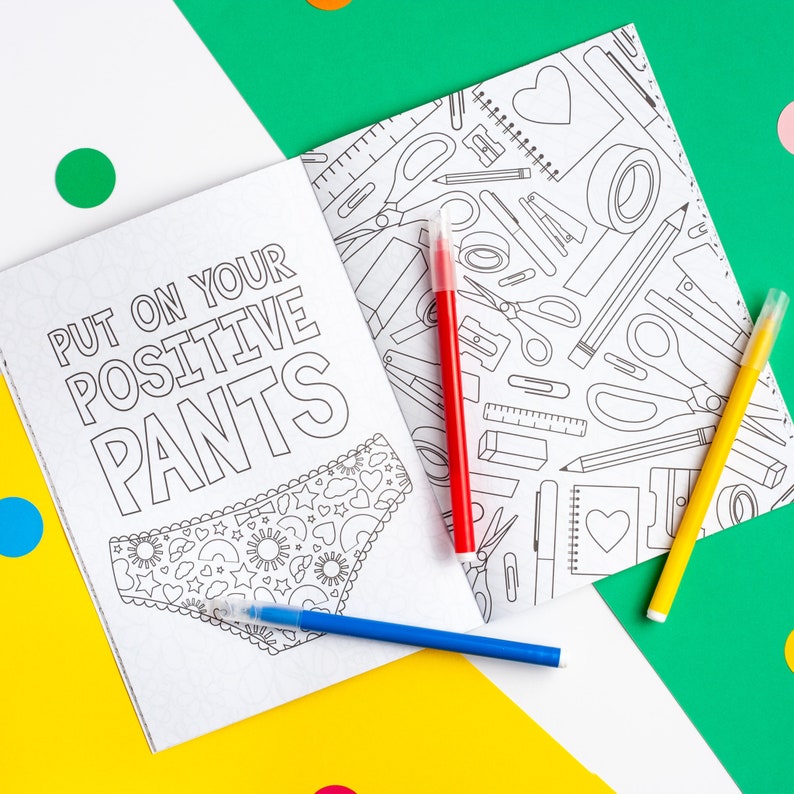 Puede incluir: Un libro para colorear con una ilustraci&oacute;n en blanco y negro de ropa interior con un patr&oacute;n de corazones y estrellas. El texto en la portada dice "Put on your positive pants". La parte posterior del libro tiene una ilustraci&oacute;n en blanco y negro de varios &uacute;tiles escolares.