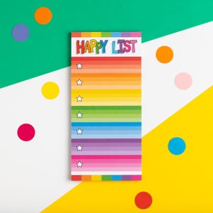 May include: A rainbow-striped notepad with the words "Happy List" printed in black and white. The notepad has white stars on each line and is surrounded by colourful dots.