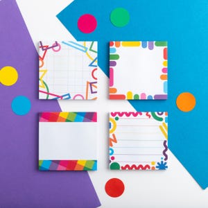 May include: Four square sticky notes with vibrant geometric borders and blank spaces for notes. The notes are set against a white surface with a purple and blue backdrop, and colourful circular accents.