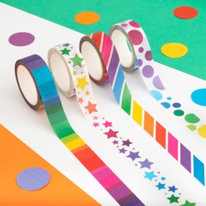 Puede incluir: Vista a&eacute;rea de cinco rollos de cinta adhesiva decorativa con dise&ntilde;os coloridos. Los dise&ntilde;os de la cinta incluyen rayas, estrellas y lunares en un arco&iacute;ris de colores. El fondo presenta c&iacute;rculos coloridos dispersos sobre superficies blancas y verdes.