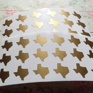 Può includere: Un foglio di adesivi in ​​foglio d'oro con il contorno dello stato del Texas. Ci sono 24 adesivi sul foglio.