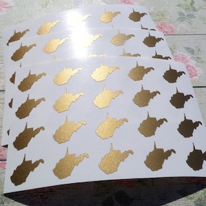 May include: Three sheets of white sticker paper with gold West Virginia state outline stickers. Each sheet has 12 stickers.
