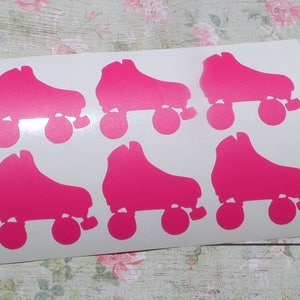 May include: Sheet of six bright pink roller skate stickers. Each sticker features a side profile of a roller skate with four wheels. The stickers are on a white background.