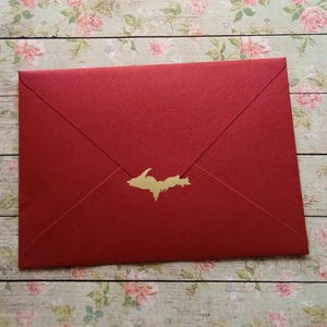 May include: Red envelope with a gold foil outline of the state of Michigan.