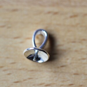 May include: Silver-toned pendant bail with a loop at the top and a flat, round base with a small hole in the centre.