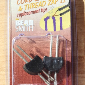 May include: Two black replacement tips for a Cord Zap & Thread Zap II tool, packaged in a clear plastic blister pack with the Bead Smith logo and product name.