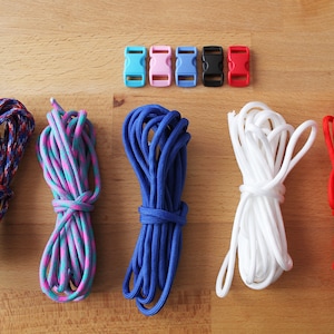 May include: Five spools of colourful paracord in red, blue, white, pink and blue with black and white stripes, and five plastic clasps in blue, pink, blue, black and red.