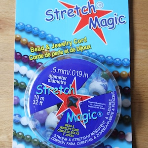 May include: A spool of 0.5 mm diameter stretch magic bead and jewellery cord. The spool is blue and white with a red star and the text "Stretch Magic" in red. The cord is 10 metres or 32.8 feet long. The cord is strong and stretchy, and is perfect for making jewellery.