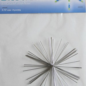 May include: A pack of eight silver snowflake wire forms, each measuring 3.75 inches wide. The pack includes a colourful beaded snowflake design on the front.