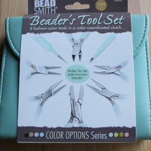 May include: A turquoise leather pouch with a zip closure contains a set of eight beading tools. The tools are colour-coordinated and include a variety of pliers and tweezers. The pouch has the text "Bead Smith" and "Beaders Tool Set" printed on the front. The text "Color Options Series" is printed below the tools.