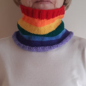 May include: A rainbow knit neck warmer with a purple ribbed trim. The neck warmer is made of soft yarn and is perfect for keeping warm in the winter.
