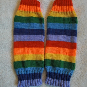 Puede incluir: Un par de calentadores de piernas de punto con un esquema de colores arcoíris. Los calentadores de piernas presentan bandas de rojo, naranja, amarillo, verde, azul y morado. Los puños son de un tono morado más oscuro. Hecho de material de punto suave.