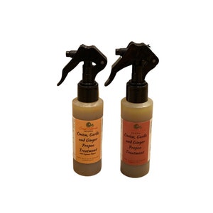 May include: Two brown glass bottles with black spray tops. The bottles are labeled "Onion, Garlic and Ginger Prepoo Treatment".