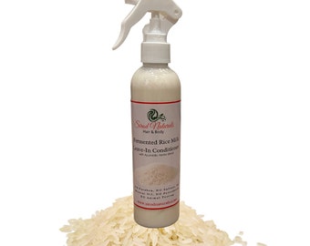 May include: A white plastic spray bottle with a white label that reads "Sirod Naturals Hair & Body Fermented Rice Milk Leave-In Conditioner with Ayurvedic Herbs Blend NO Parabens, NO Sulfates, Mineral Oil, NO Petrochemicals NO Animal Testing www.sirodnaturals.com". The bottle is sitting on a pile of white rice.