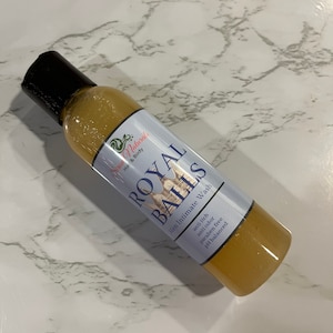 May include: A clear amber bottle with a black cap and a label that reads "Siraa Naturals Hair & Body ROYAL BALLS Men Intimate Wash anti itch anti odor paraben free pH balanced".