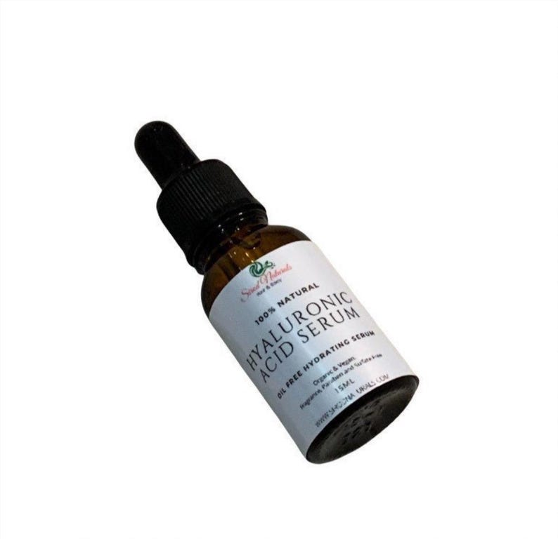 May include: A brown glass bottle with a dropper top containing Hyaluronic Acid Serum. The bottle is labeled with white text that reads "100% Natural Hyaluronic Acid Serum Oil Free Hydrating Serum Organic & Vegan 15ML".