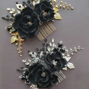 Puede incluir: Dos peinetas florales negras con detalles dorados y plateados. Cada peineta presenta flores de tela, cristales y detalles de cuentas. Las peinetas est&aacute;n dise&ntilde;adas con hojas y tallos met&aacute;licos dorados y plateados.