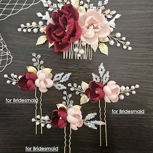 May include: Set of four gold hair combs with burgundy and blush pink fabric flowers, pearls, and crystals. The larger comb is labelled "for Bride" and the smaller combs are labelled "for Bridesmaid".
