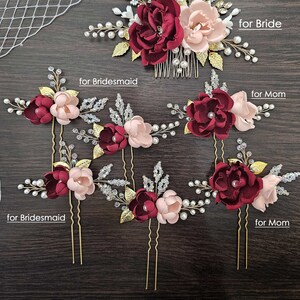 May include: Set of seven burgundy and blush floral hair combs and pins with gold accents, pearls, and rhinestones. The set includes one comb and six pins. The text "Set of 7" and "for Bride" are visible in the image.