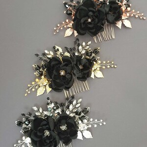 Puede incluir: Tres peinetas florales negras con detalles dorados, plateados y negros. Cada peineta presenta flores de tela, adornos de cuentas y detalles de hojas met&aacute;licas. Las peinetas est&aacute;n dispuestas sobre un fondo gris.
