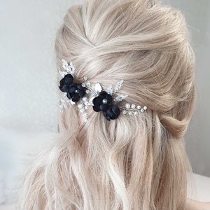 Puede incluir: Primer plano de un peinado rubio adornado con dos horquillas de flores negras. Las horquillas est&aacute;n adornadas con cristales y peque&ntilde;as cuentas blancas. El cabello est&aacute; peinado en un estilo semi recogido.