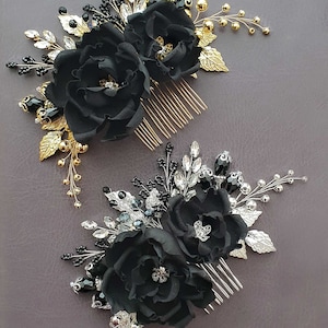 Op de afbeelding: Twee zwarte bloemen haar kammen met gouden en zilveren versieringen. Elke kam is versierd met zwarte bloemen van stof, strass steentjes en kralen.