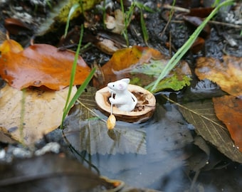 Miniature mouse paddling a boat, mjniature mouse, paddling mouse, mouse swims in walnut