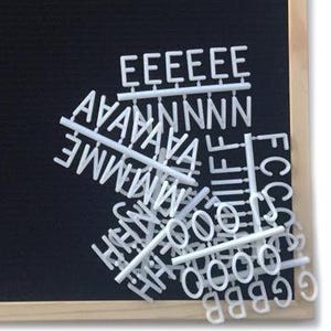 May include: White plastic letters and numbers on a black chalkboard background. The letters are arranged in a random pattern and include the letters E, A, N, M, H, I, F, O, C, G, S, and B.