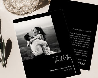 May include: Black and white wedding thank you cards with a photo of a couple embracing. The cards have a minimalist design with the words "Thank You" in elegant script. A crystal glass is in the background.