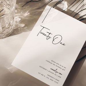 Op de afbeelding: Een witte uitnodigingskaart met zwarte tekst die "Twenty One" en "please join us as we celebrate the birthday girl" luidt. De tekst bevat ook de datum, tijd en locatie van het evenement: "SATURDAY | AUGUST 20 | 6PM", "emmalyn mae", "emmalyn's home", "123 4th st., city, state, 12345" en "Aim Beth".
