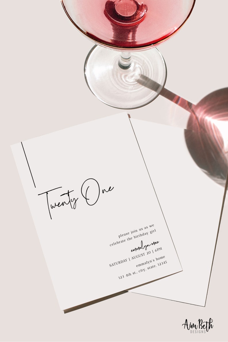 Op de afbeelding: Een witte uitnodigingskaart met zwarte tekst die "Twenty One" luidt en details voor een verjaardagsfeest bevat. De tekst bevat de naam "emmalyn wae", de datum "SATURDAY | AUGUST 20 | 6PM", de locatie "emmalyn's home" en het adres "123 4th st., city, state, 12345". De kaart ligt op een wit oppervlak met een glas wijn op de achtergrond.