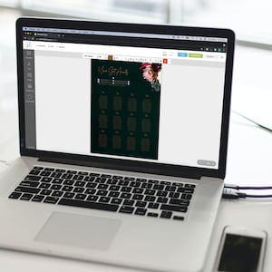 May include: A laptop computer displaying a wedding seating chart template on a screen. The template is editable and features a dark green background with gold text and a floral design. The text on the screen reads "Your Seat Awaits".