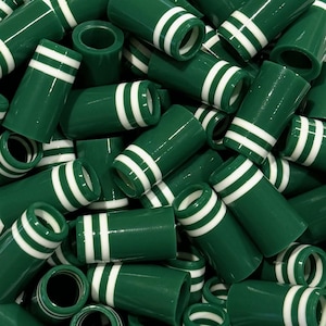 May include: A collection of green cylindrical objects with two white stripes around the top. The objects are stacked together, creating a dense pattern. The objects have a glossy finish.