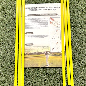 Peut inclure: Trois bâtons d'alignement de golf jaunes et noirs. Les bâtons sont pliables et peuvent être utilisés pour aider les golfeurs à améliorer leur swing. L'image comprend des instructions pour l'utilisation des bâtons.