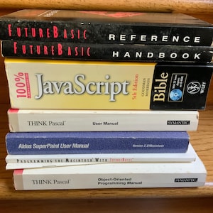 Puede incluir: Una pila de siete libros técnicos de programación informática que incluye FutureBasic Reference, FutureBasic Handbook, 100% JavaScript Bible 5th Edition, THINK Pascal User Manual, Aldus SuperPaint User Manual, Programming the Macintosh with FutureBasic y THINK Pascal Object-Oriented Programming Manual.
