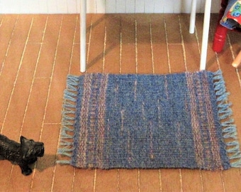 Miniature colonial dollhouse rug or table mat mug rug handwoven in striped flat woven weft face pattern. Blue and pink wool. 5" by 7.5"